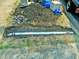 Newly installed water pipe halfway to being covered