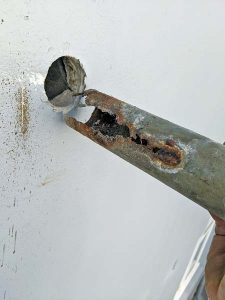 Detached from wall rusted and decayed pipe